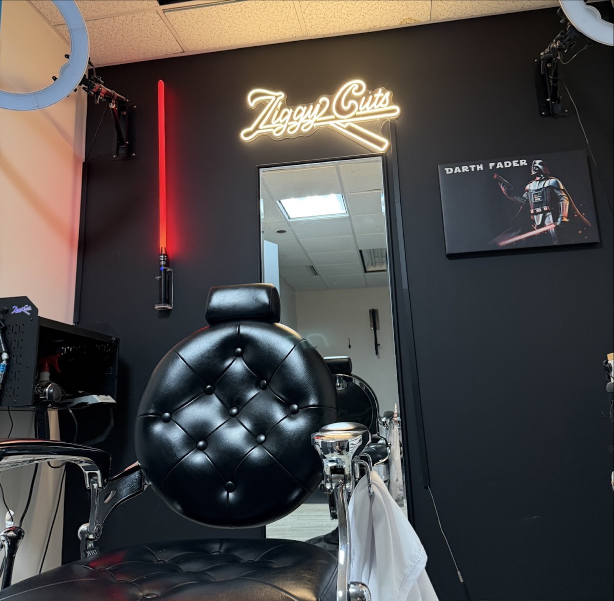 The shop: black walls, neon sign, the chair