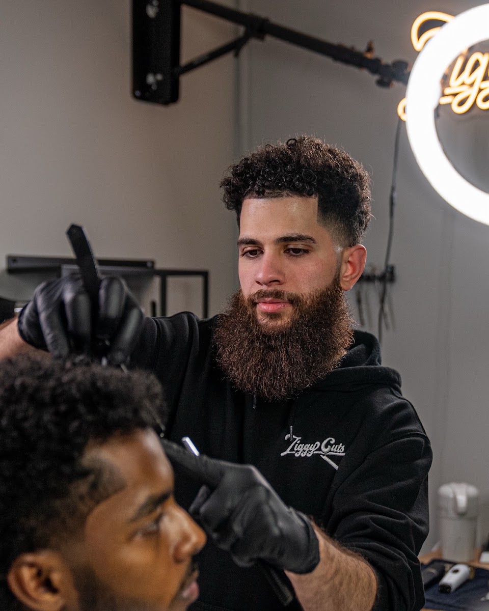 Barber detailing a hairline with a blade